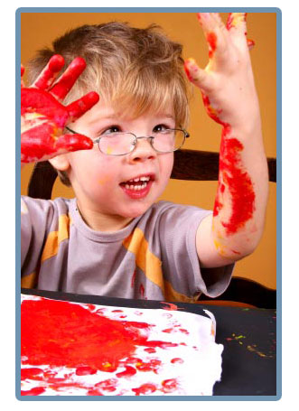 Little boy playing with red paint