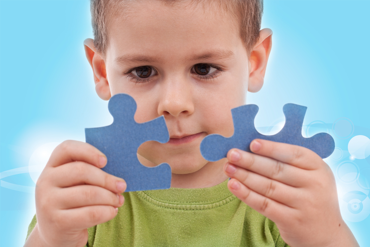 Little Boy Holding two Blue Puzzle Pieces