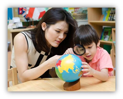 Teacher and boy using magnifying glass looking at globe